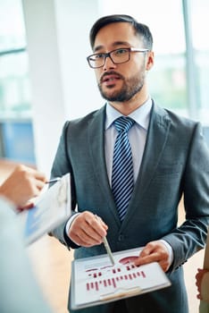 Elegant businessman explaining data to colleagues at meeting
