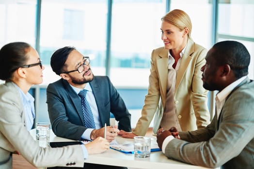 Happy businesswoman explaining her idea to employees at meeting