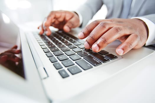 Hands of African businessman typing