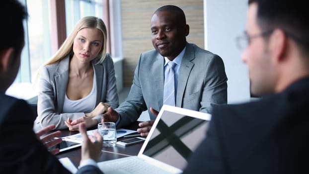 Pretty businesswoman and confident man listening to colleague at meeting