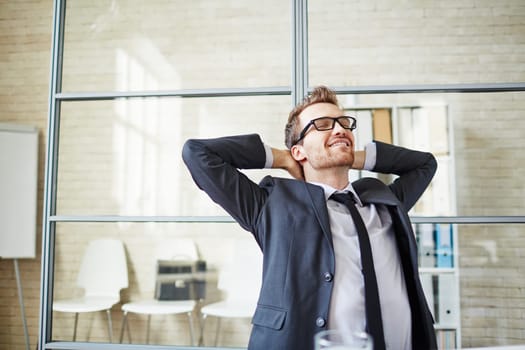 Young businessman having a little rest after work in office
