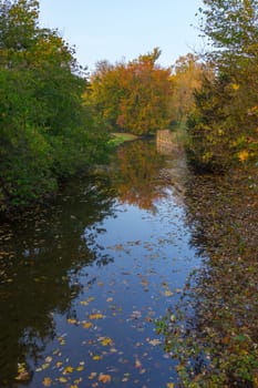 Sky is reflected in the water of a canal in the park