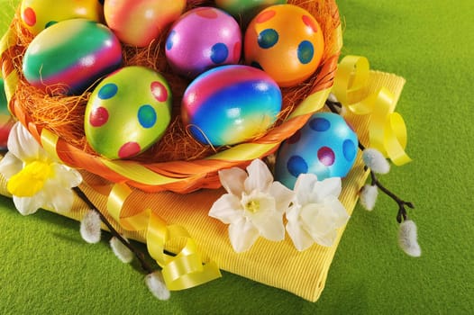 Colourful Easter basket with painted Easter eggs,daffodils and palm kittens