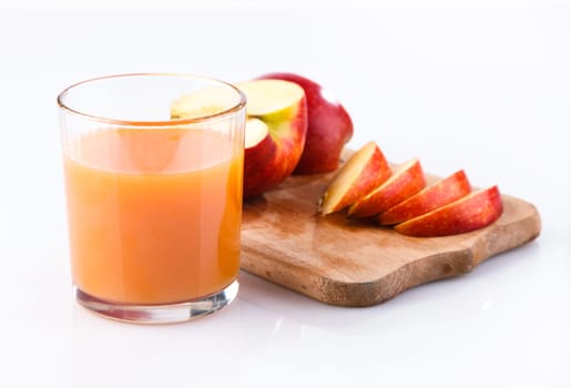 glass of juice and apple and cut into the board on a white background