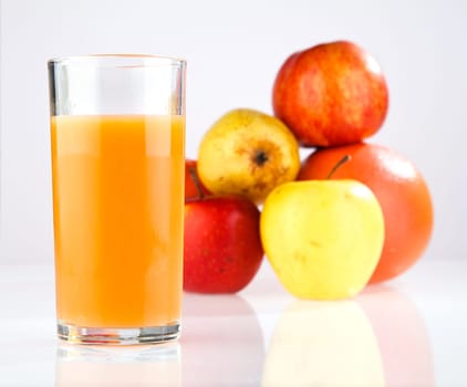 apple, pear, grapefruit, a glass of juice on a white background