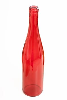Red glass empty bottle on a light background.