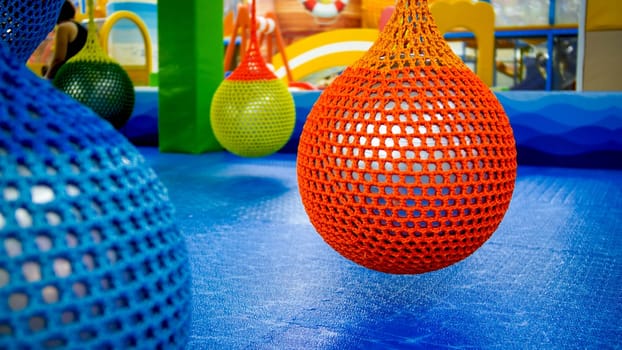 Colorful inflatable balls in nets hanging at gym.