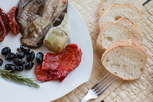 Italian antipasti as dinner appetizer. Tomatoes, Olives, paprika and more.