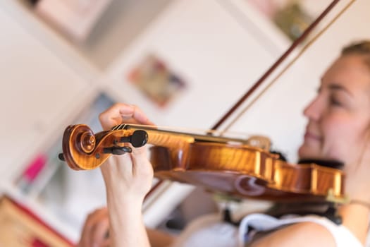 Pretty young girl practices on her violin, acoustic music