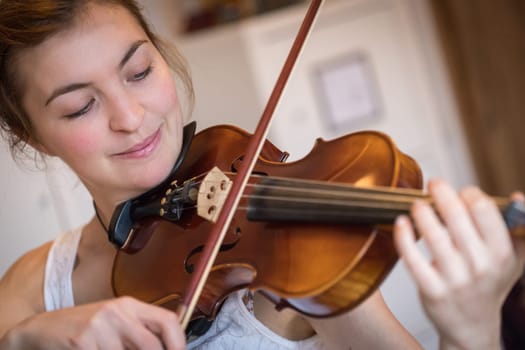 Pretty young girl practices on her violin, acoustic music