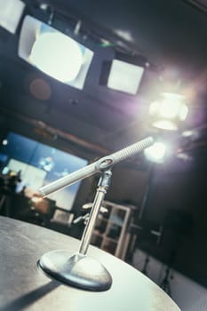 Metal microphone in the studio, studio lights in the blurry background