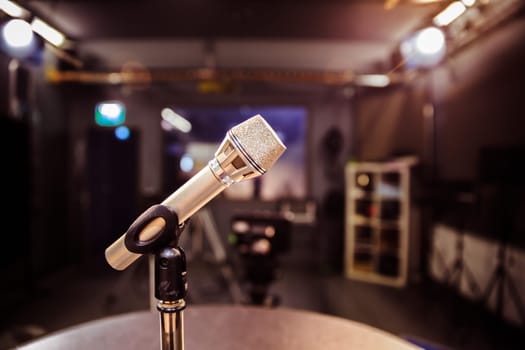 Metal microphone in the studio, studio lights in the blurry background