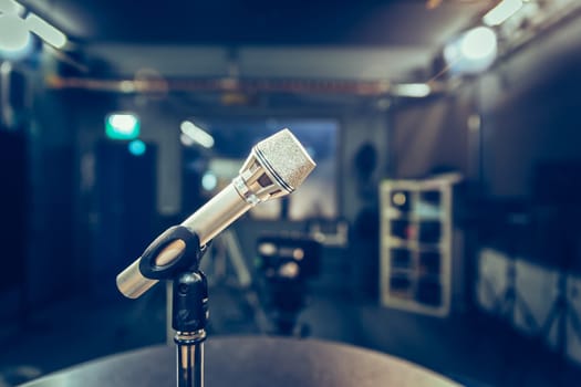 Metal microphone in the studio, studio lights in the blurry background