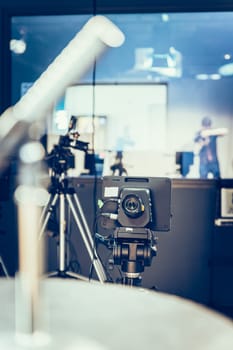 Film camera on a tripod in a television broadcasting studio, spotlights and equipment
