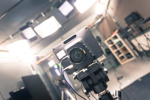 Lens of a film camera in an television broadcasting studio, spotlights and equipment