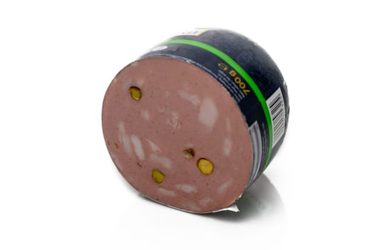 A round slice of deli meat reveals a blend of flavors, with pistachios adding a pop of color and texture.