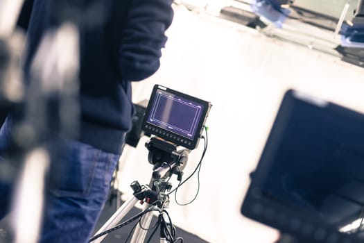 Male cameraman is operating a film camera in a television studio