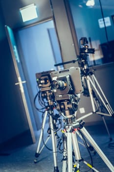 Film camera on a tripod in a television broadcasting studio, spotlights and equipment
