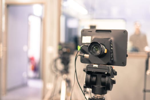 Lens of a film camera in an television broadcasting studio, spotlights and equipment