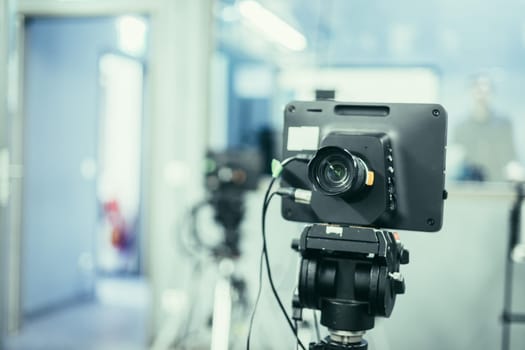 Lens of a film camera in an television broadcasting studio, spotlights and equipment