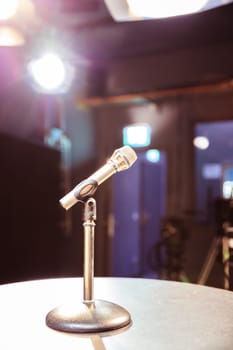 Metal microphone in the studio, studio lights in the blurry background