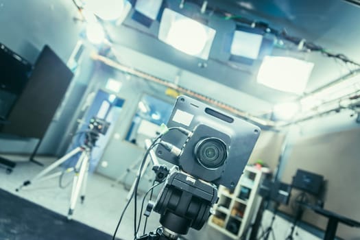Lens of a film camera in an television broadcasting studio, spotlights and equipment