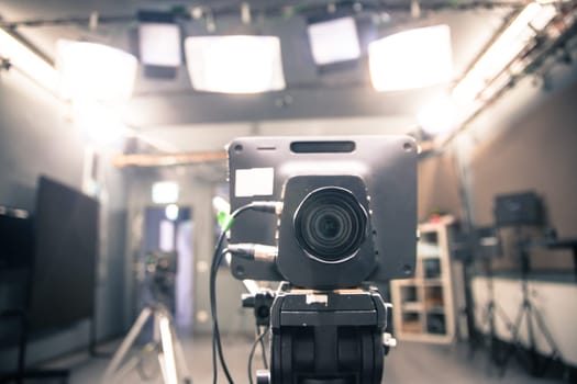 Lens of a film camera in an television broadcasting studio, spotlights and equipment