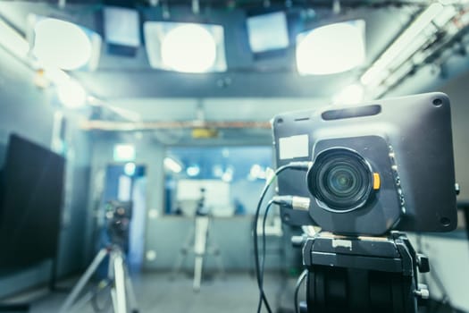 Lens of a film camera in an television broadcasting studio, spotlights and equipment