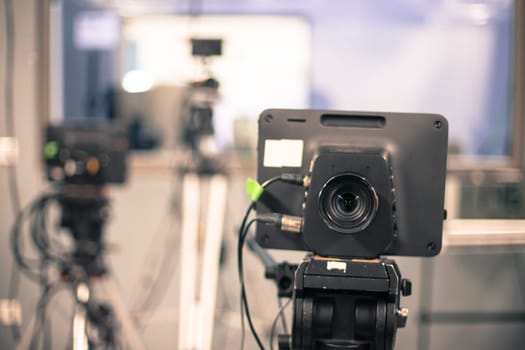 Lens of a film camera in an television broadcasting studio, spotlights and equipment
