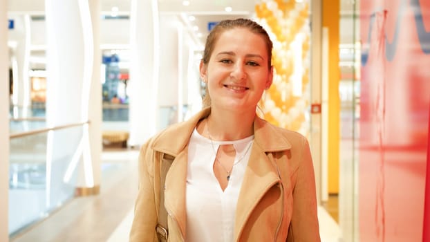 Portrait of beautiful elegant young woman posing in big shopping mall.