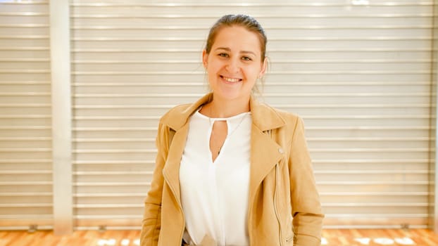 Portrait of beautiful smiling woman standing on city street.