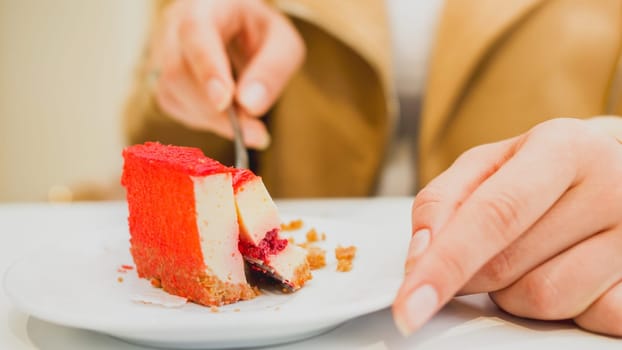 Toned photo of young woman eating sweet cake in cafe.