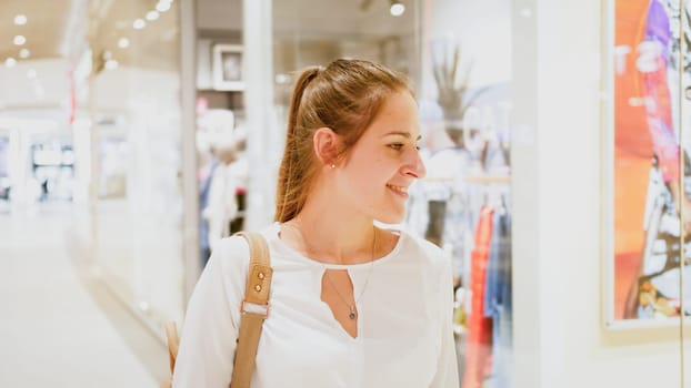 Portrait of young beautiful woman walking in shopping mall during season sale.