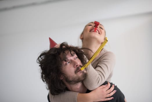 happy young romantic  couple in love  celebrating and blowing confetti decorations at new year and charismas  party