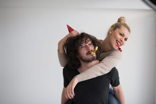 happy young romantic  couple in love  celebrating and blowing confetti decorations at new year and charismas  party