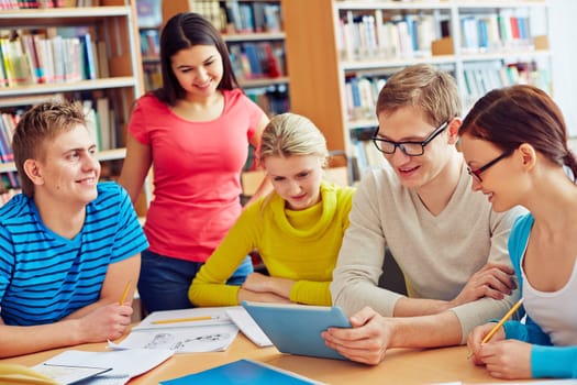 Group of friendly students discussing news in library