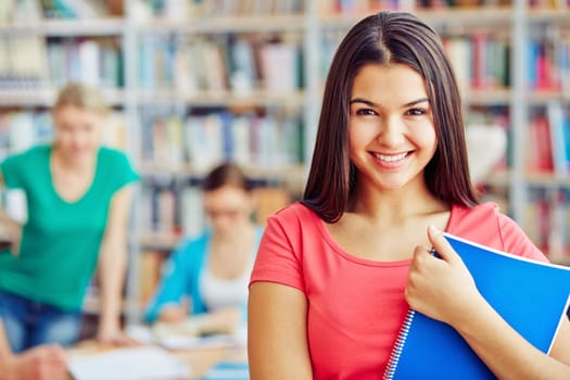 Smiling teenager with copybook looking at camera