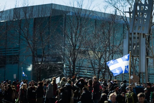 MONTREAL, CANADA, APRIL 02 2015. Riot in the Montreal Streets to counter the Economic Austerity Measures. Someone Holding Quebec Province Flag in the crowd