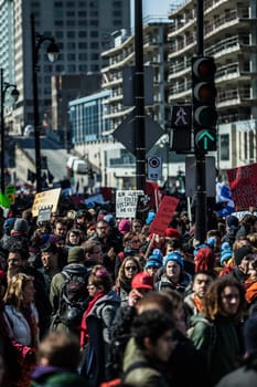 MONTREAL, CANADA, APRIL 02 2015. Riot in the Montreal Streets to counter the Economic Austerity Measures. Crowd with Placard, Flags and Signs Walking in the Streets