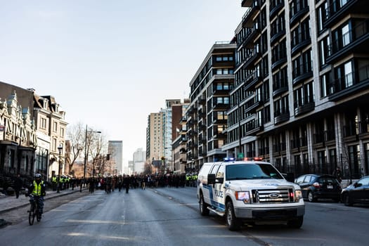 MONTREAL, CANADA, APRIL 02 2015. Riot in the Montreal Streets to counter the Economic Austerity Measures. Police Pick-up Truck in front of the Protesters controlling the Traffic