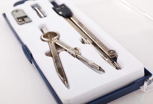 Pair of drawing compasses set on a white background