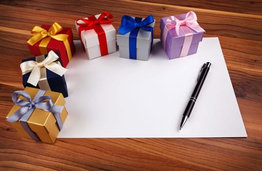 blank card with a pen and colored gift boxes