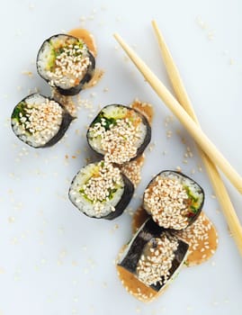 Traditional japanese sushi sprinkled with sesame seeds isolated on white background top view