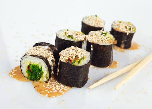 Traditional japanese sushi with sauce and sesame seeds isolated on white background