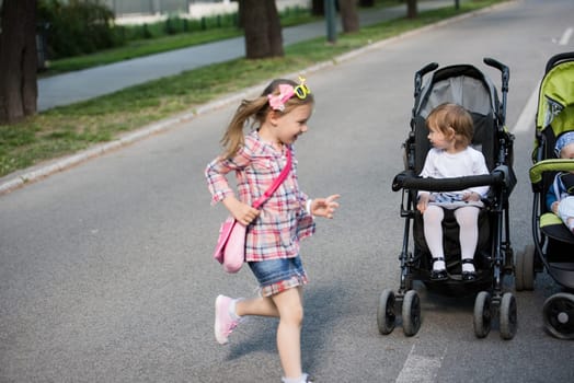 beautiful babies sitting in a stroller in the park