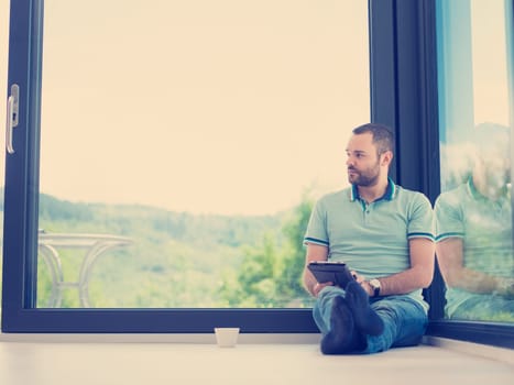Real man Using tablet on the floor At Home Drinking Coffee Enjoying Relaxing