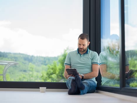 Real man Using tablet on the floor At Home Drinking Coffee Enjoying Relaxing