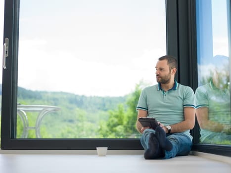 Real man Using tablet on the floor At Home Drinking Coffee Enjoying Relaxing