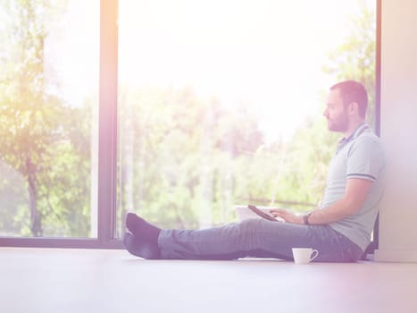 Real man Using tablet on the floor At Home Drinking Coffee Enjoying Relaxing