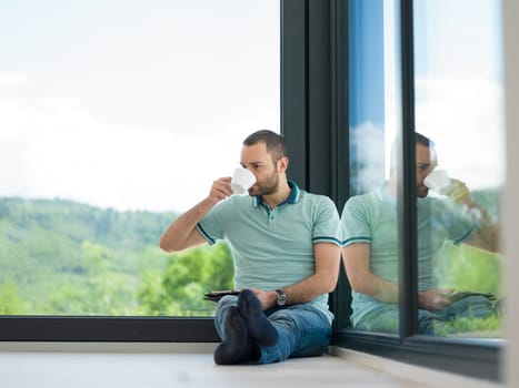 Real man Using tablet on the floor At Home Drinking Coffee Enjoying Relaxing